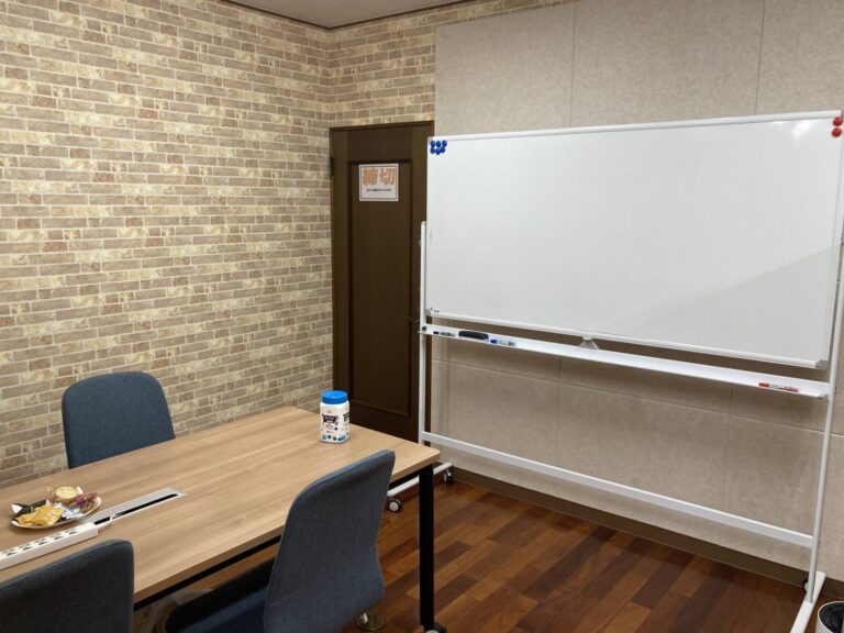 Meeting room with a whiteboard writing surface and a wood-finish table